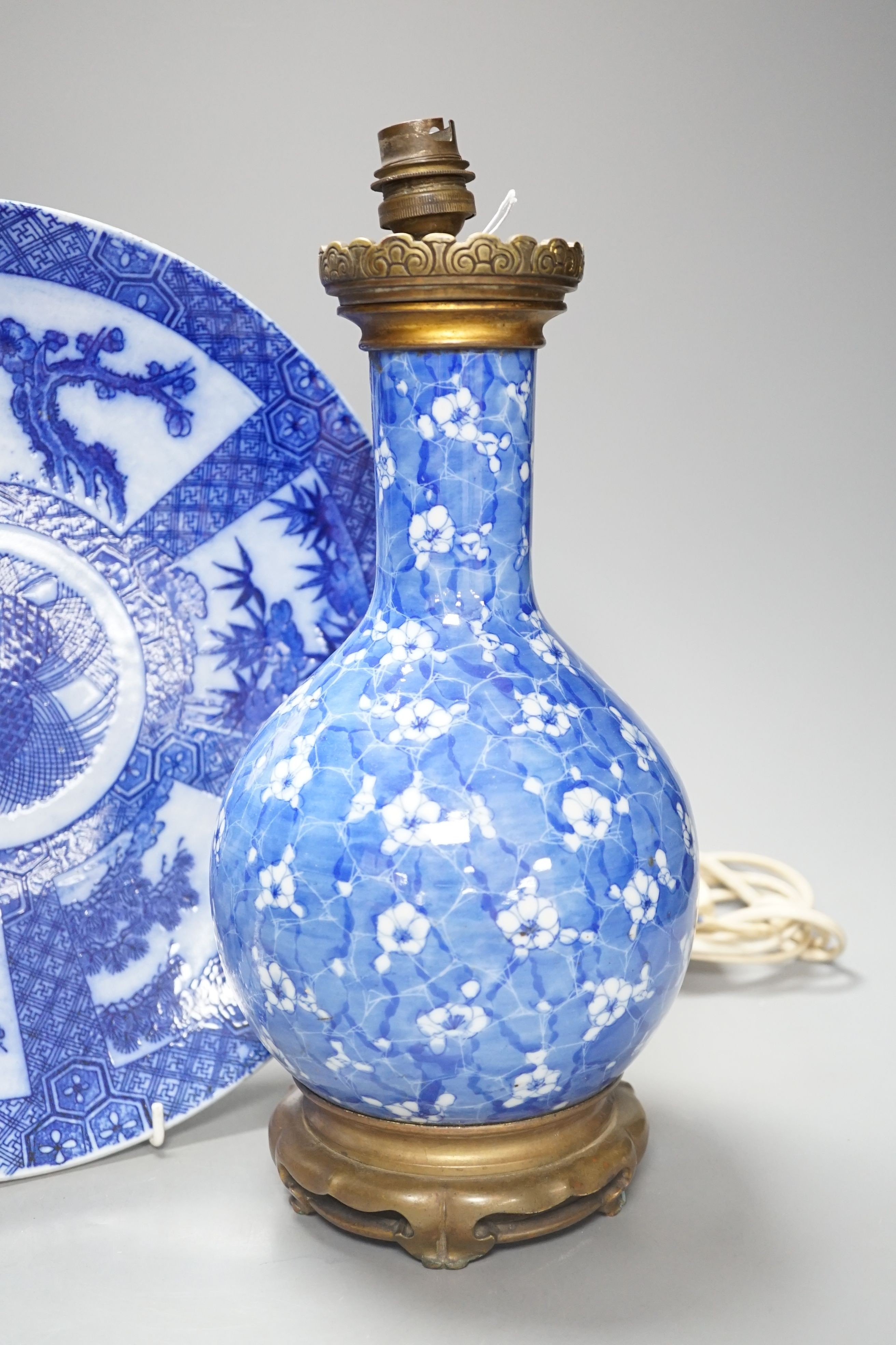 A Japanese prunus blue and white vase now as a lamp, together with a blue and white charger, 34cm diameter